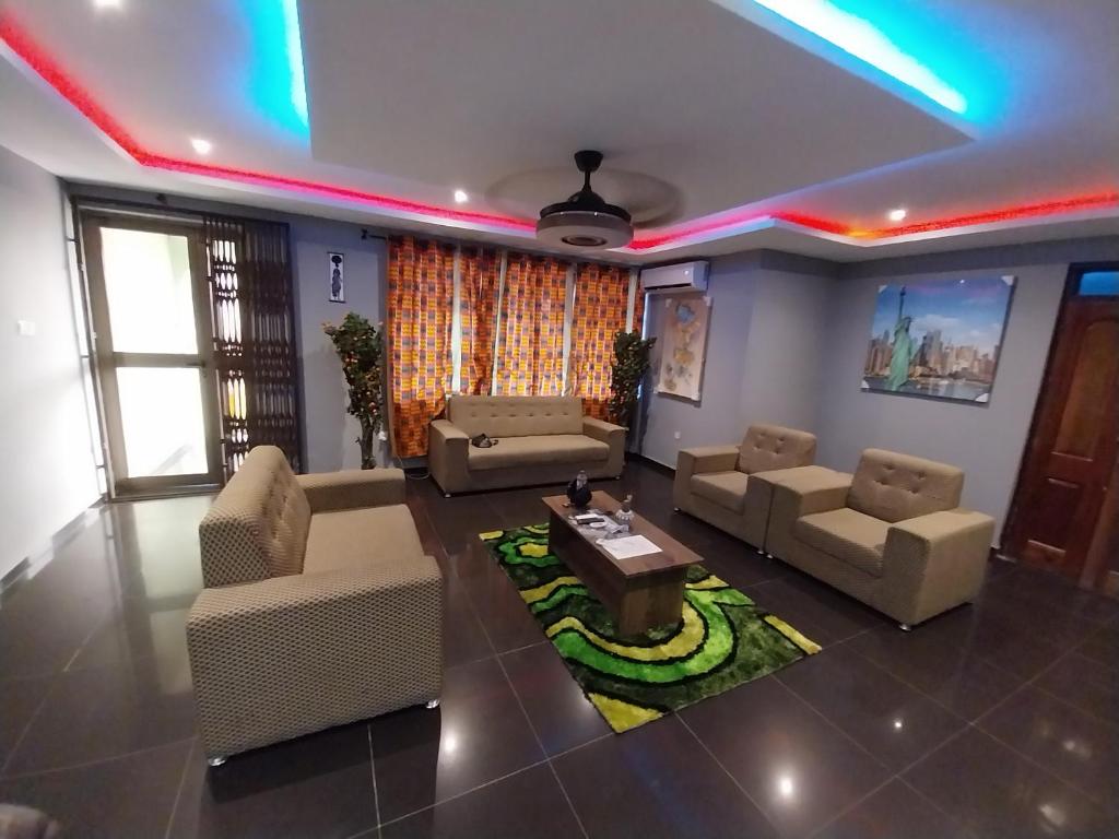 een woonkamer met banken en een tafel op een tapijt bij Gilbert Dai Ventures in Ashalebotwe