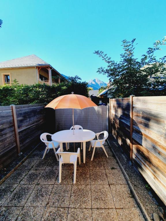 a table and chairs with an umbrella on a patio at Appartement T2 30m2 Vielle Aure in Vielle-Aure