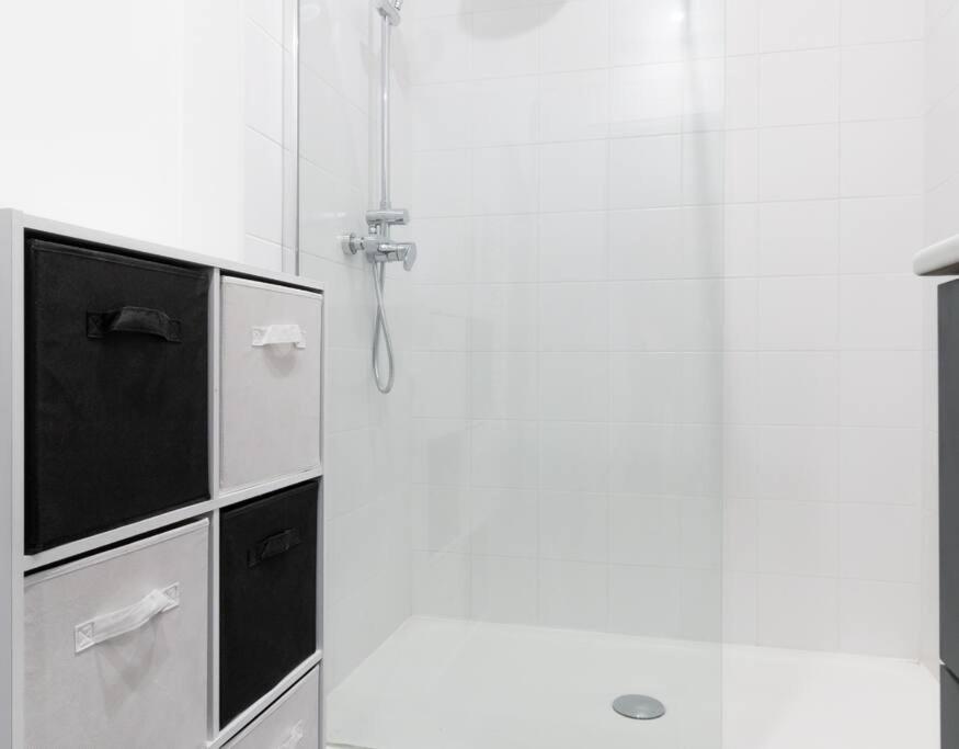 a shower in a white bathroom with a glass door at Chambre qualité hôtel 4 etoiles dans un appartement partagé in Frouzins