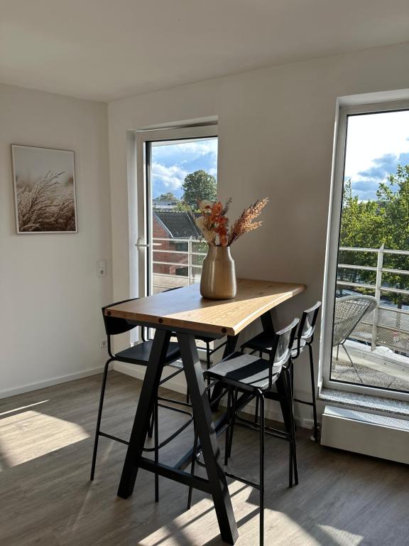 a table and chairs in a room with a window at Mango Living - Hideaway -, Dachterrasse, 77qm, 2 Schlafzimmer, 6 Personen, am Hauptbahnhof Rheydt in Mönchengladbach