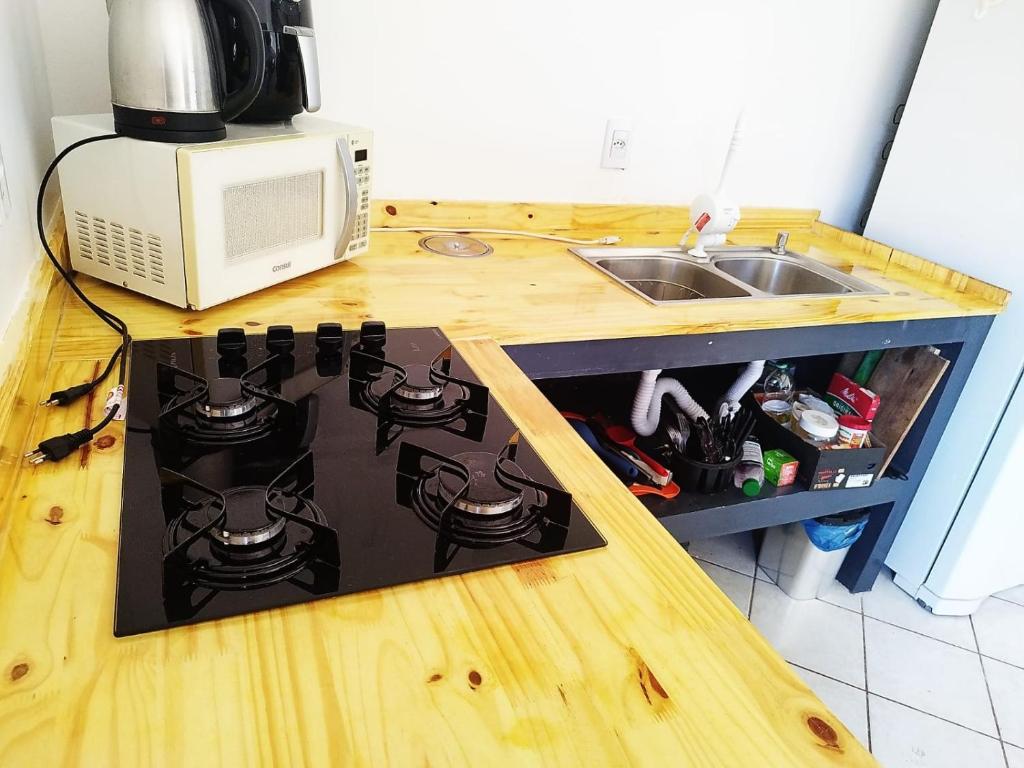 um balcão de cozinha com um fogão e um micro-ondas em Quarto privativo WC compartilhado em Joinville