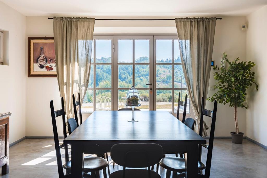 un tavolo da pranzo con sedie e una grande finestra di La Magnanella - Luxury B&B a Fornovo di Taro