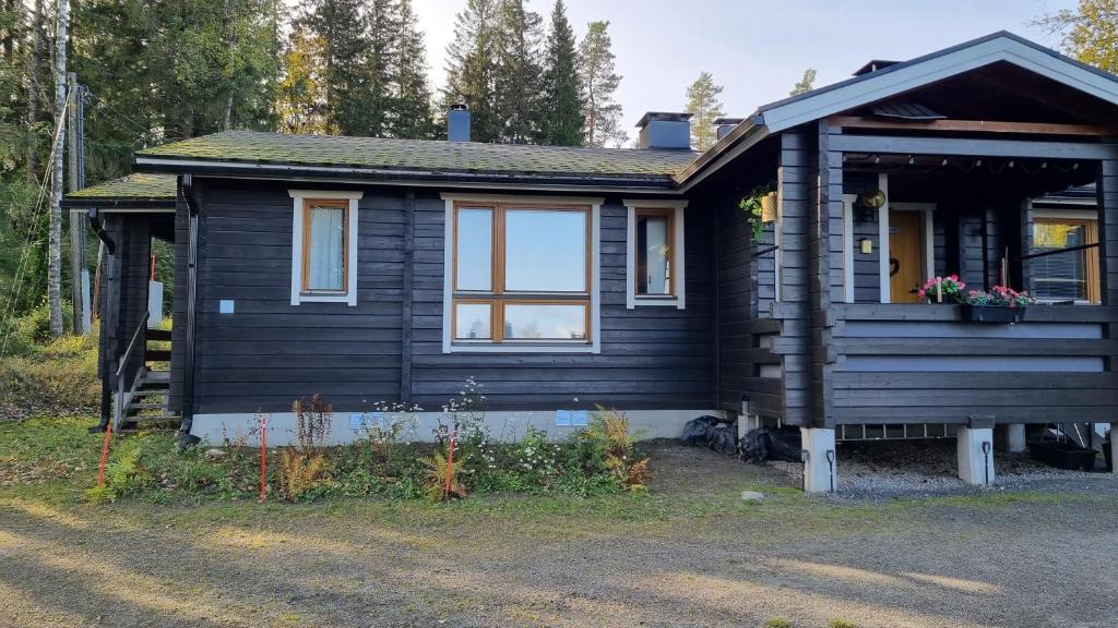 a black tiny house with a porch and a window at Lomariihi 11 in Muurame