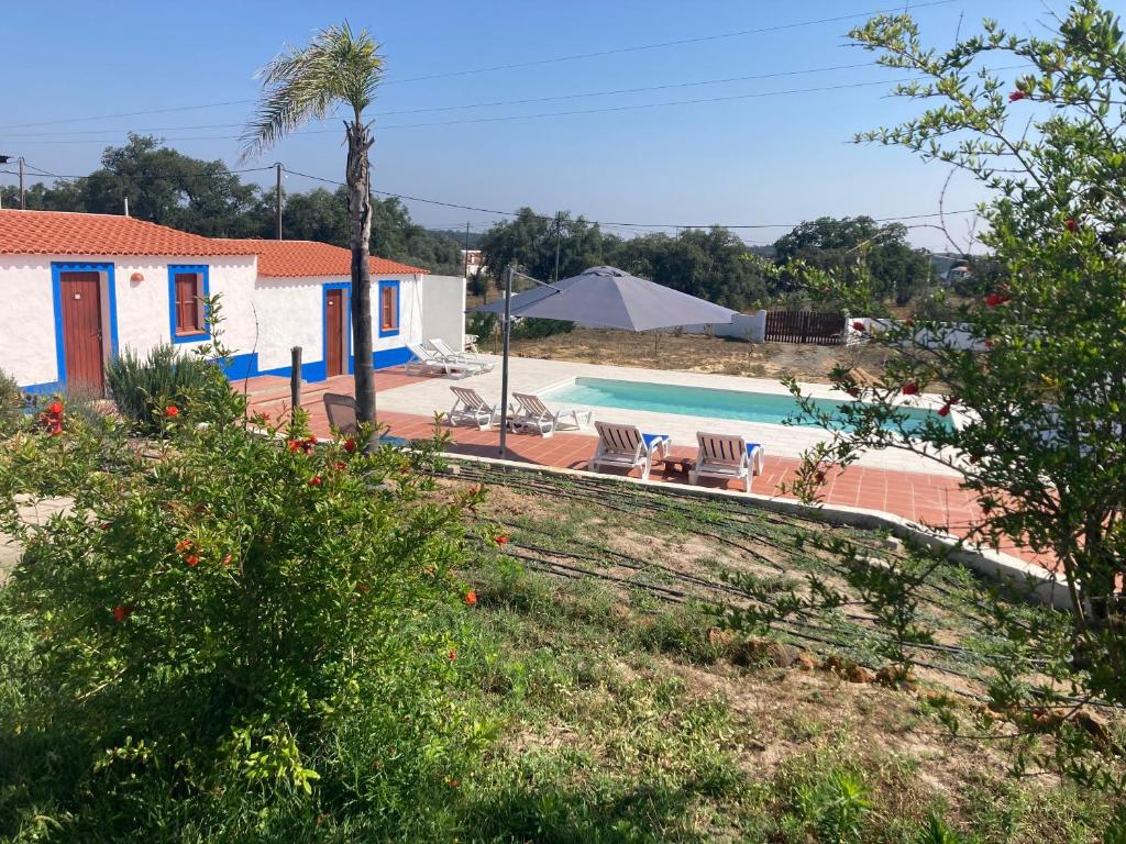 uma villa com uma piscina e uma casa em Monte das Flores 