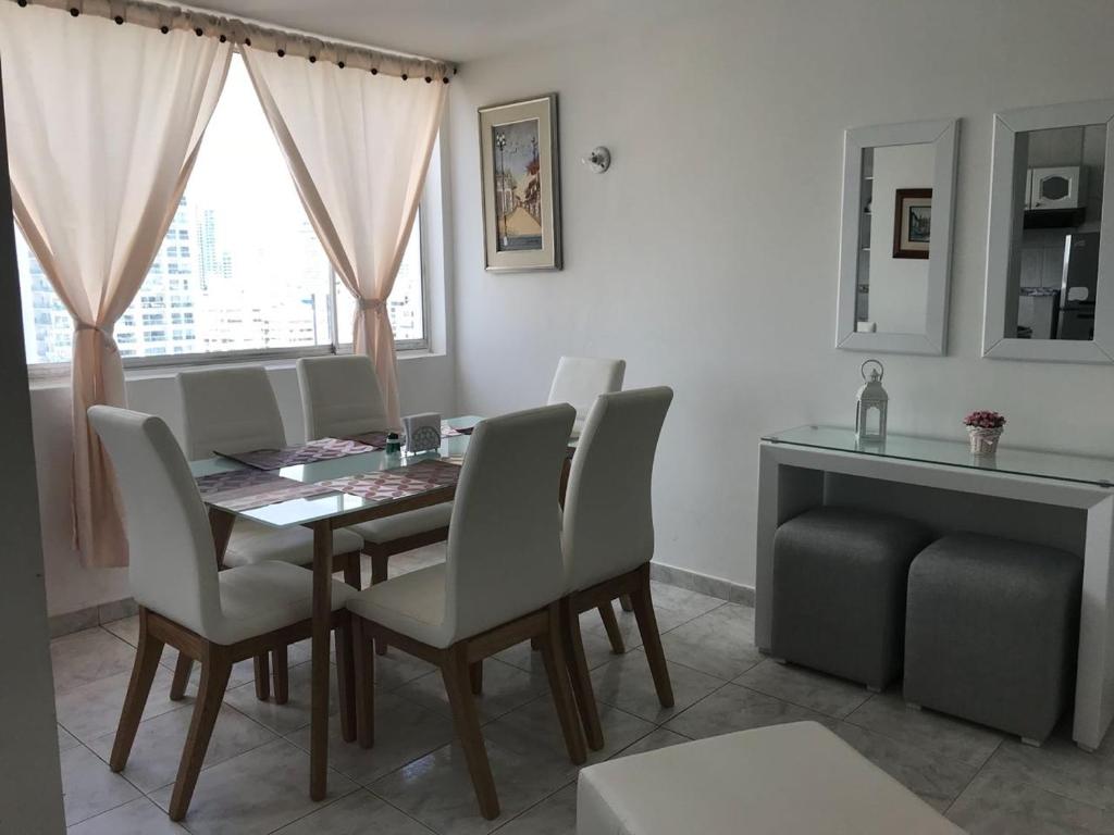 a dining room with a table and chairs and a window at Los delfines in Cartagena de Indias