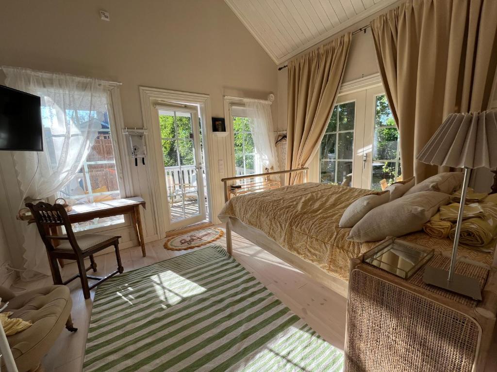 a bedroom with a bed and a desk and windows at Villa Tilda in Matildedal
