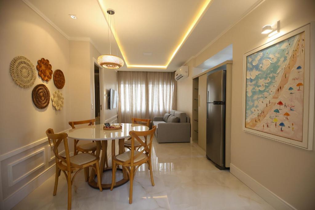 a dining room with a table and chairs and a couch at Flat Beira Mar in Fortaleza