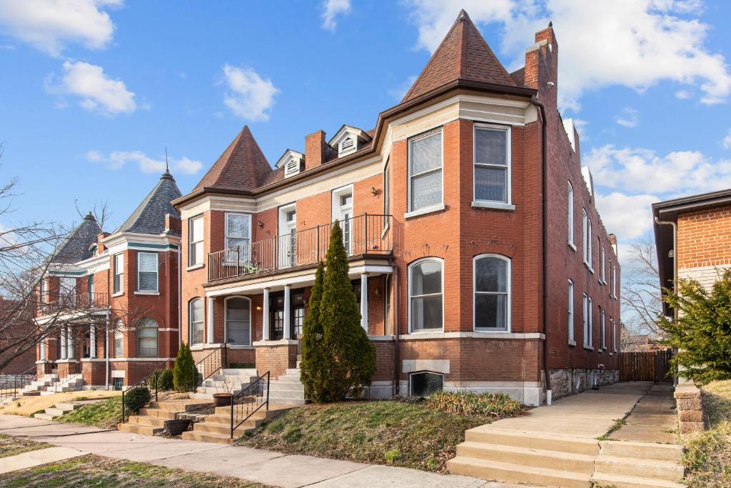 un grand bâtiment en briques rouges avec une tourelle dans l'établissement Exquisitely Designed Townhome - JZ Vacation Rentals, à Saint-Louis