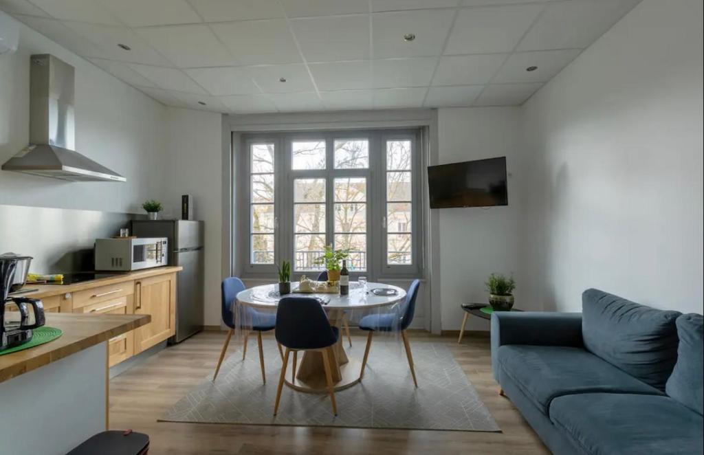 cocina y sala de estar con mesa y sofá en Résidence Harmonie Appartement N 3 Meublé Avec Petit Déjeuner, en Néris-les-Bains