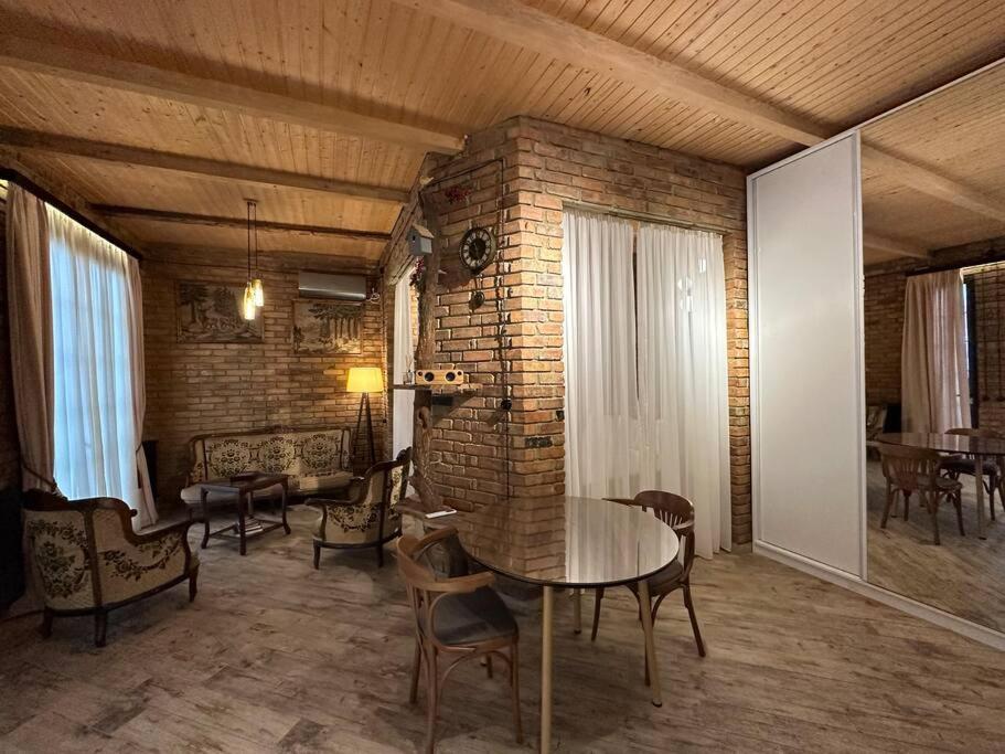 a room with a table and chairs and a brick wall at Сity center Loft style Apartment in Tbilisi City