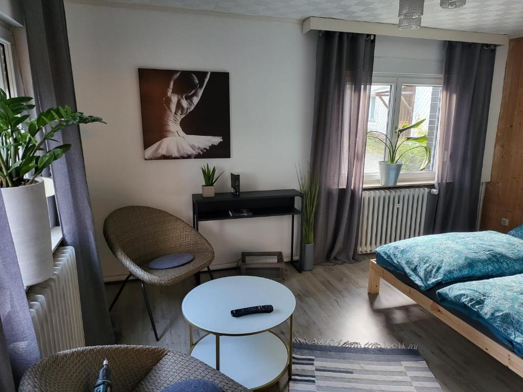 una pequeña sala de estar con cama y mesa. en Das hinter Haus, en Rohrbach