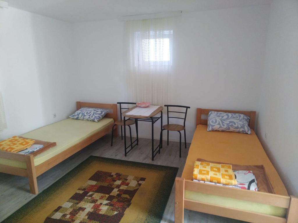 Pokój z 2 łóżkami, stołem i krzesłami w obiekcie Kursumlija w mieście Kuršumlija
