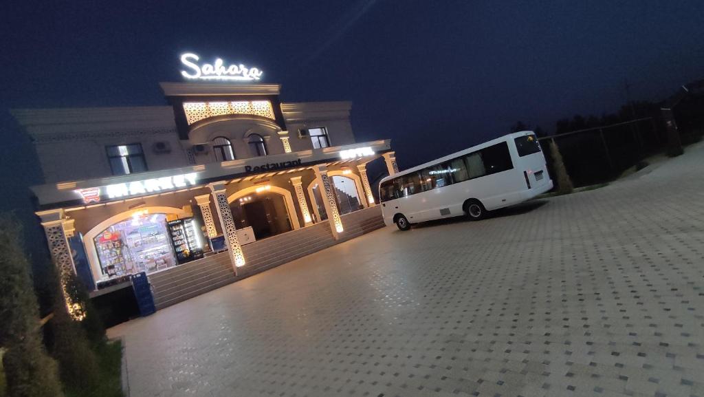 a bus parked in front of a building at night at Байсун. Гостиница.Сахара in Baysun