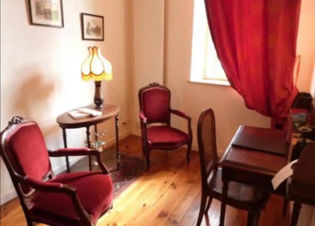 sala de estar con sillas y mesa con lámpara en Chez Vanessa, en Saint-Gervais-dʼAuvergne