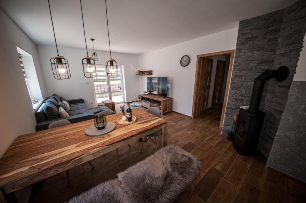 a living room with a wooden table and a fireplace at Apartmán na Žlábku in Horní Planá