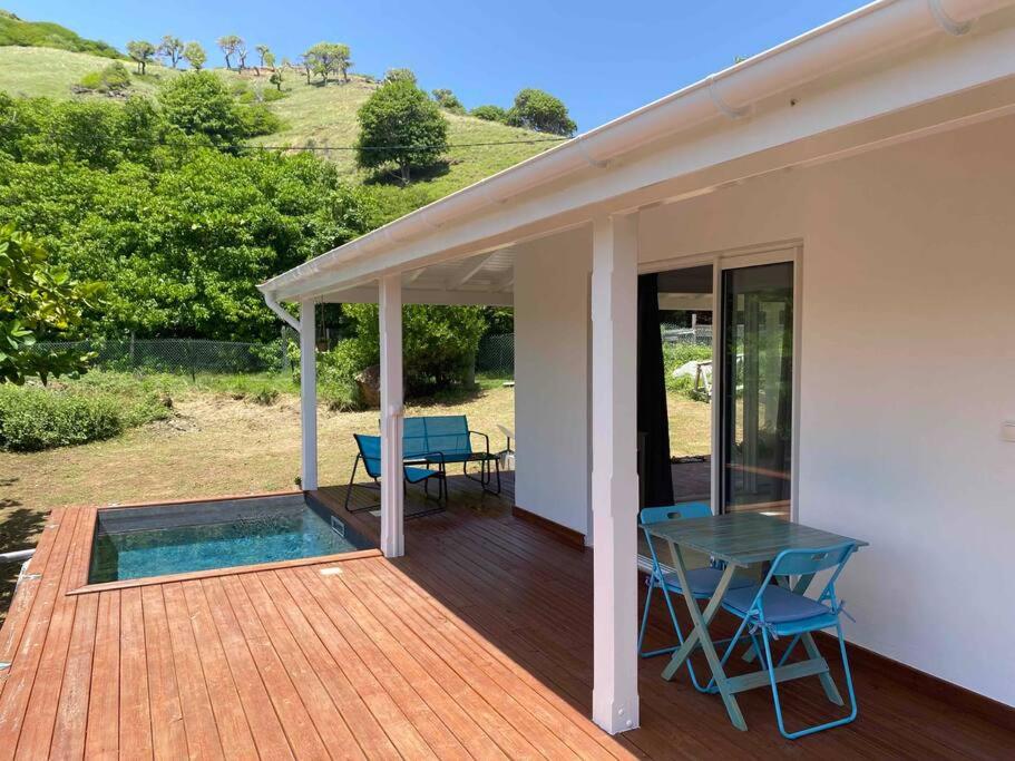 a porch of a house with a table and chairs at Bungalow l&#39;amandier avec piscine in Terre-de-Haut