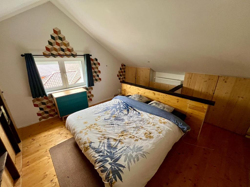 1 dormitorio con 1 cama con cabecero de madera y ventana en Capstay La Louvière, en La Louvière