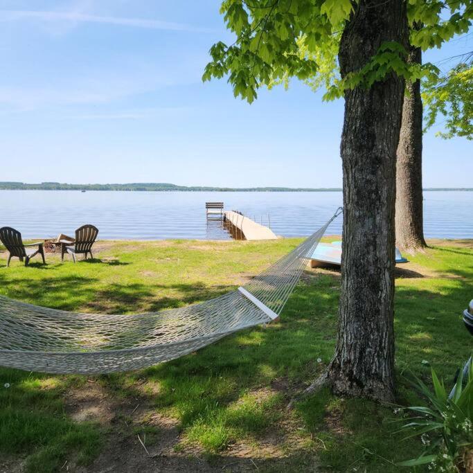 a hammock hanging from a tree next to a lake at Cottage on Shawano Lake. On The Beach in Shawano