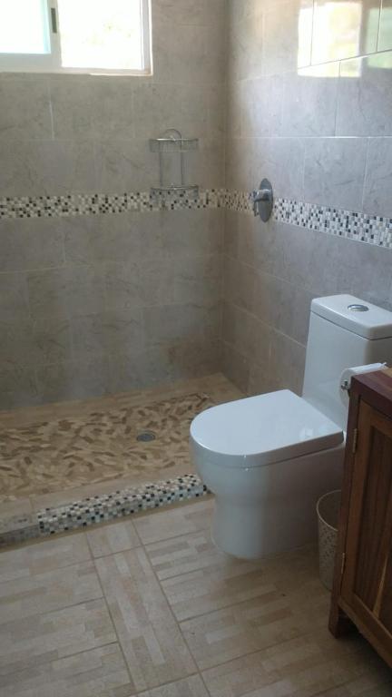 y baño con aseo blanco y ducha. en Casa Delfines en Puerto Escondido