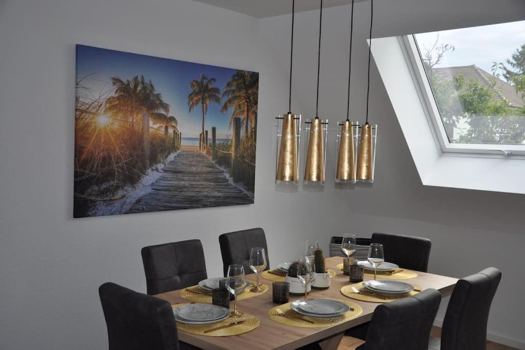 une table à manger avec des chaises et un tableau mural dans l'établissement Wohnung in Eggenstein-Leopoldsh., 