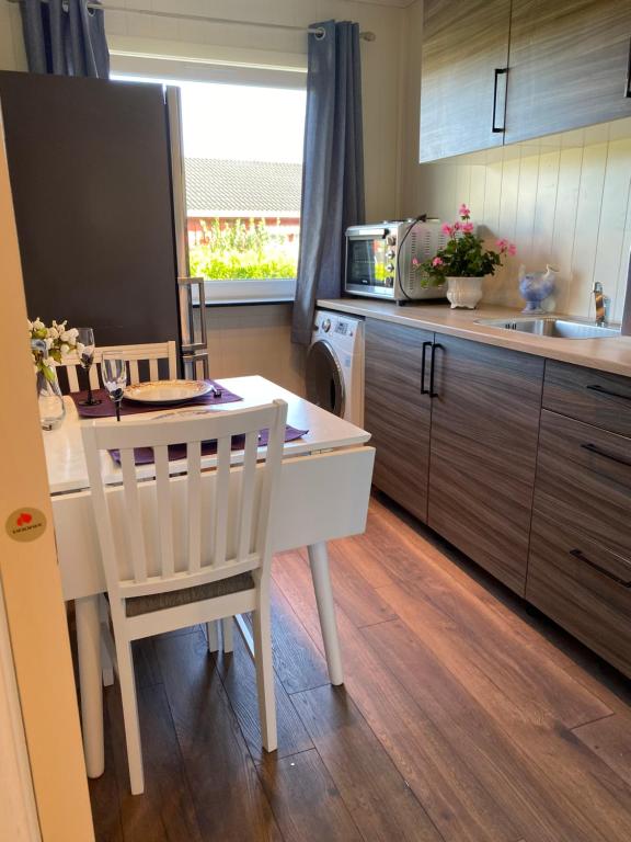 una cucina con tavolo, sedie e lavandino di comfortable apartment in a quiet area in the city center a Skien