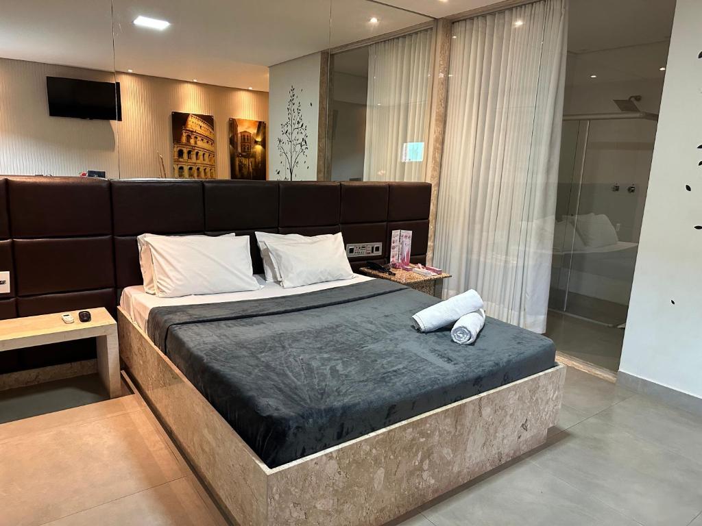 um quarto com uma cama grande e uma grande cabeceira. em Motel Orion - Belo Horizonte em Belo Horizonte