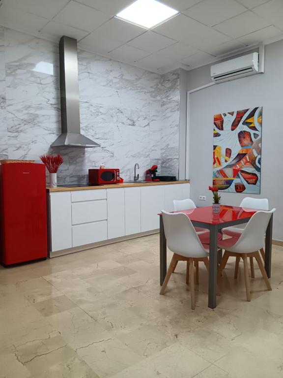 cocina con nevera roja, mesa y sillas en Apartamentos Tierra Bobal, en Requena