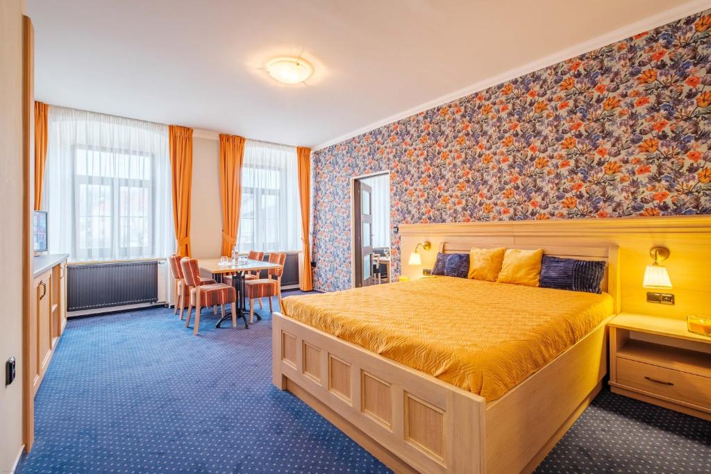 pokój hotelowy z łóżkiem i stołem w obiekcie Hotel Orličan w mieście Rokytnice v Orlických Horách