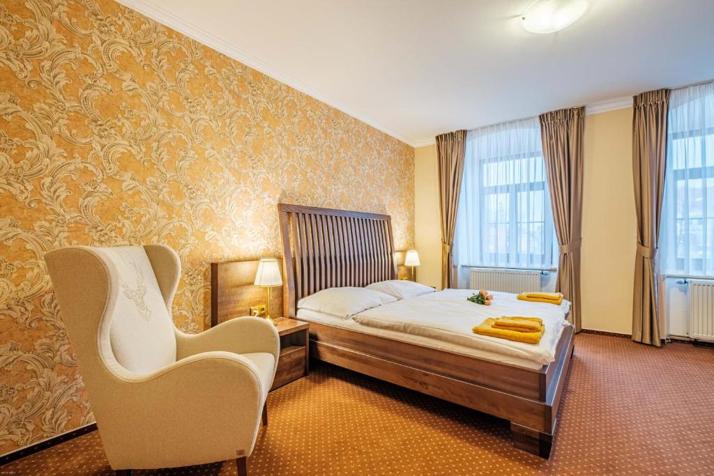 Pokój hotelowy z łóżkiem i krzesłem w obiekcie Hotel Orličan w mieście Rokytnice v Orlických Horách