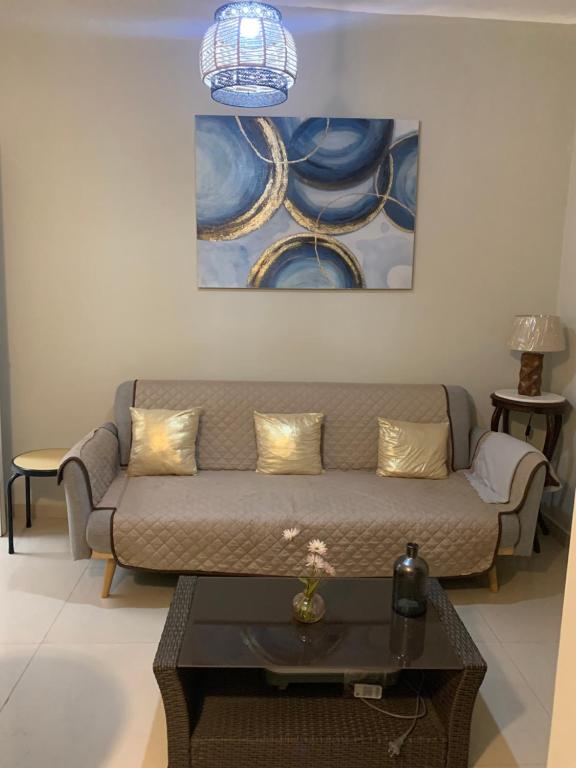 a living room with a couch and a painting on the wall at Apartamento Miraflores in Lima