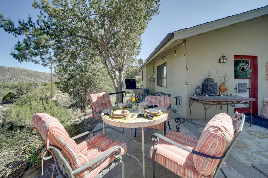a patio with a table and chairs on a porch at Tuscan Getaway with Premier Vineyard Views! in Cottonwood