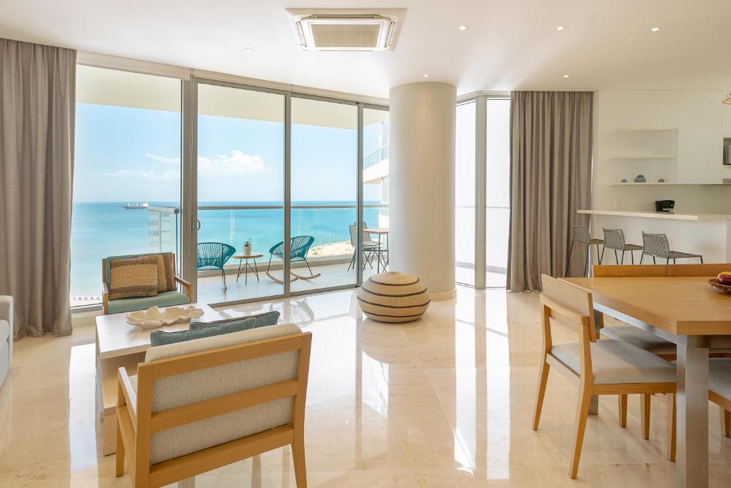 a dining room with a view of the ocean at Grand Marina Suites Santa Marta in Santa Marta