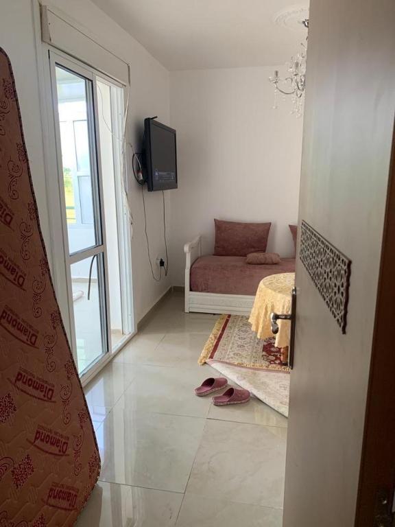 een woonkamer met een bank en een televisie. bij appartement face du mere in Tanger