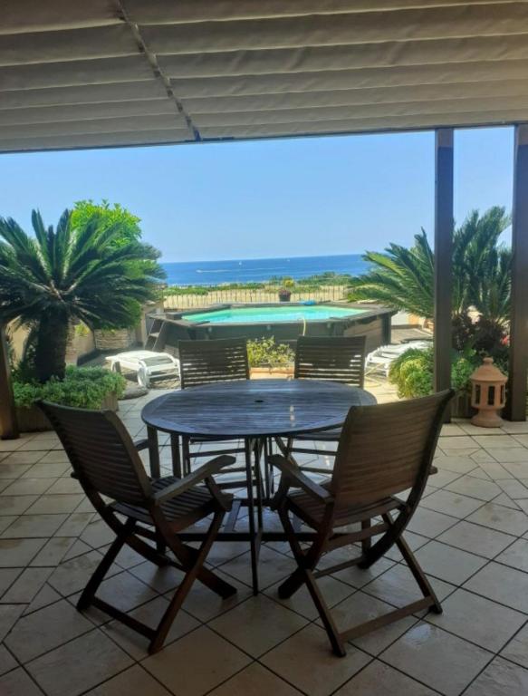 a table and chairs on a patio with a view of the ocean at Michelangelo-Sunset-Villa in Santa Marinella