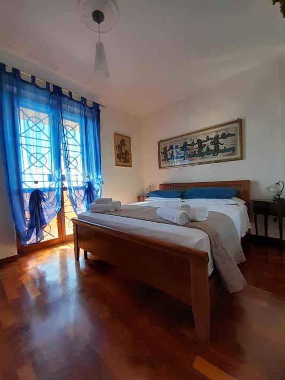Un dormitorio con una cama grande con cortinas azules. en Michelangelo-Sunset-Villa, en Santa Marinella