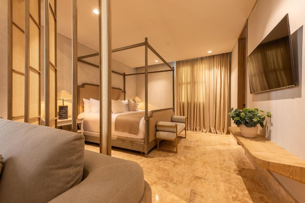 pokój hotelowy z łóżkiem i kanapą w obiekcie Cinco Quintas Hotel Boutique By SOHO w mieście Cartagena de Indias