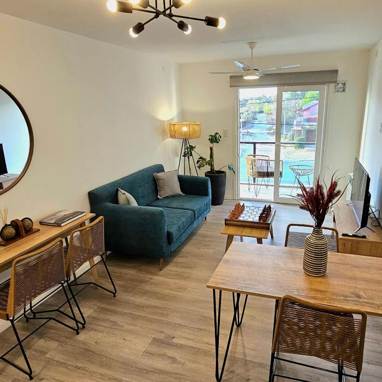 a living room with a blue couch and a table at Balcón Edén Apart in La Falda