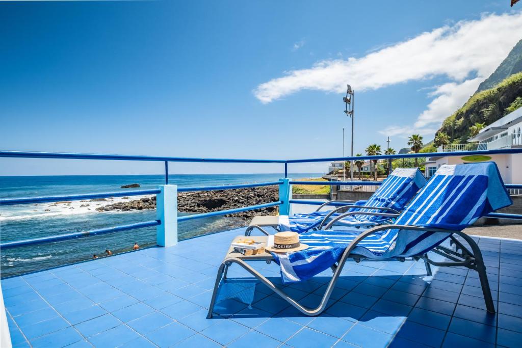 Sea House في ساو فيسينتي: زوج من الكراسي الزرقاء على شرفة تطل على المحيط