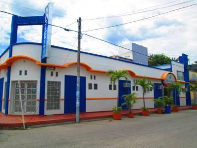 un edificio azul y blanco con plantas delante en Hotel Bucaros, en Espinal