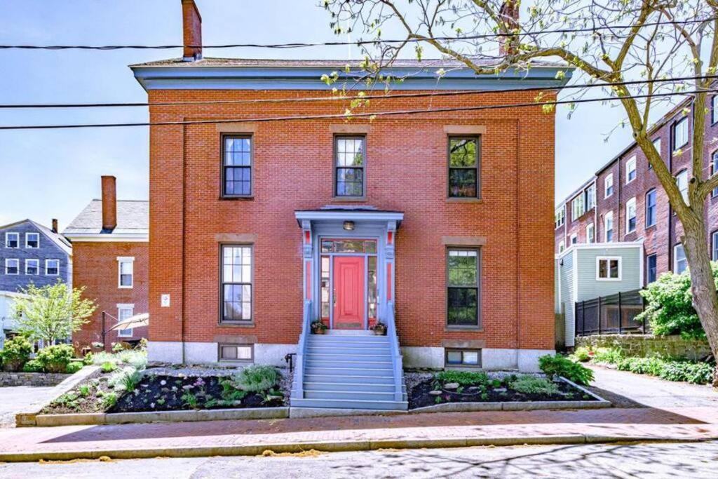 una casa de ladrillo rojo con puerta roja en Historic Corner Apartment with patio & off street parking, en Portland