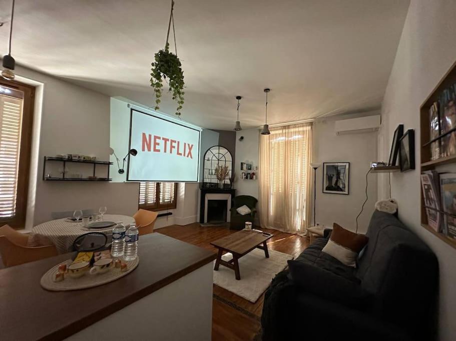 a living room with a netflix sign on the wall at Duplex loft - Central avec home cinéma in Annecy