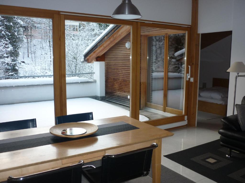 ein Esszimmer mit einem Tisch, Stühlen und einem Fenster in der Unterkunft Moderne attraktive Dachwohnung für max. 6 Personen in ruhiger Umgebung in Flims