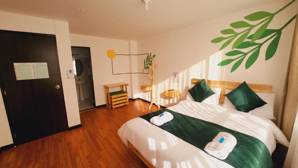 a bedroom with a bed with green and white sheets at Hotel Natural Sevgi in Bogotá
