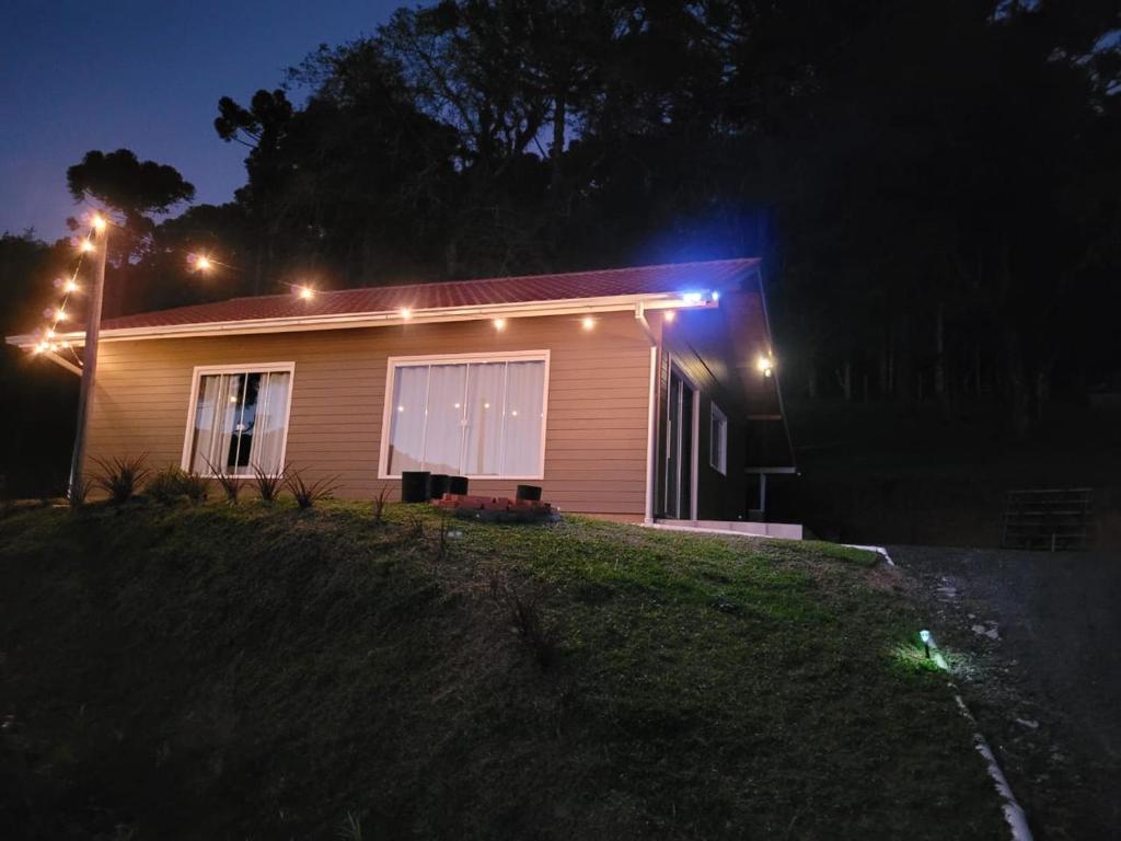 Una casa con luces en el costado por la noche. en Recanto Pôr do Sol, en Urubici