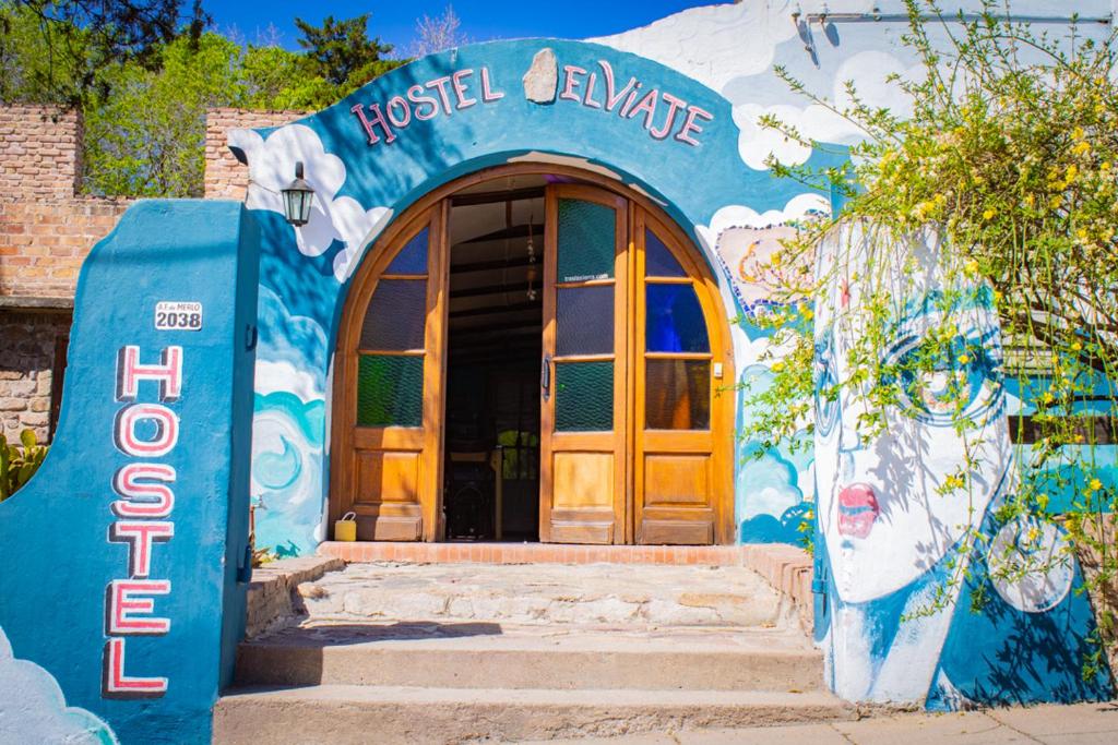 un edificio azul con un cartel que lee el campus Bush en El Viaje Hostel en Mina Clavero