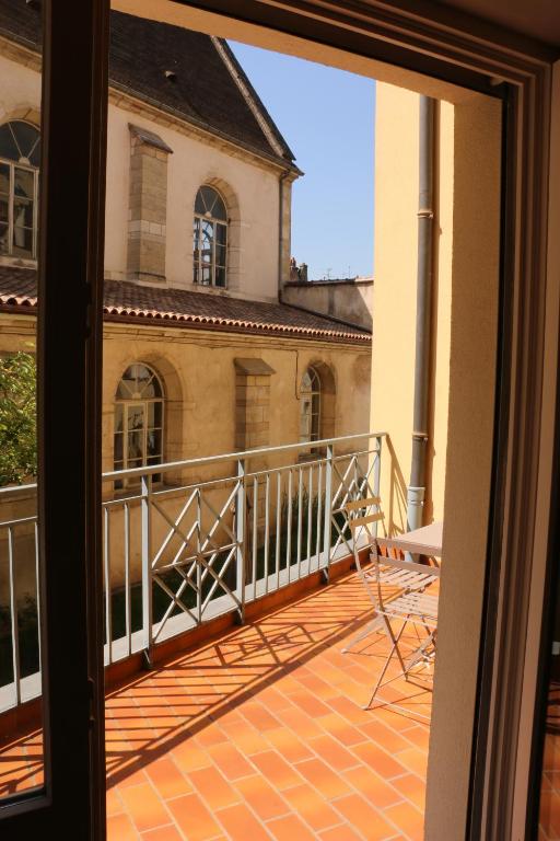 un balcon avec vue sur un immeuble dans l'établissement Appartement Le Saint-Etienne avec Terrasse, à Beaune
