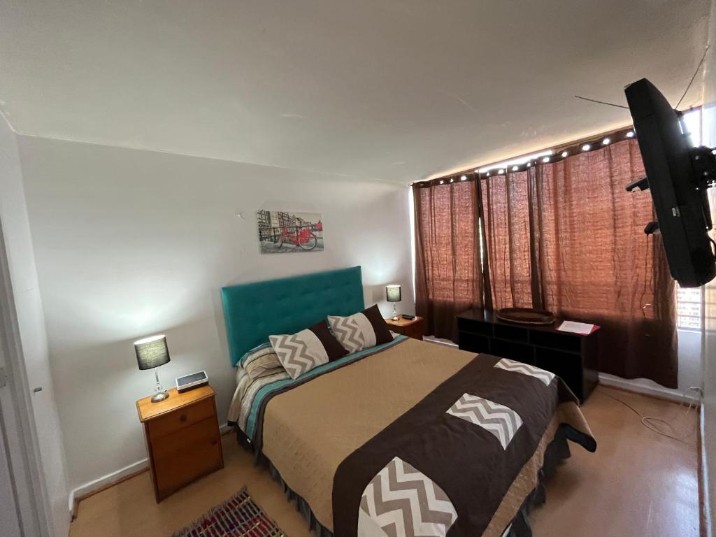 a bedroom with a bed and a television in it at Apartment Relocation San Isidro in Santiago