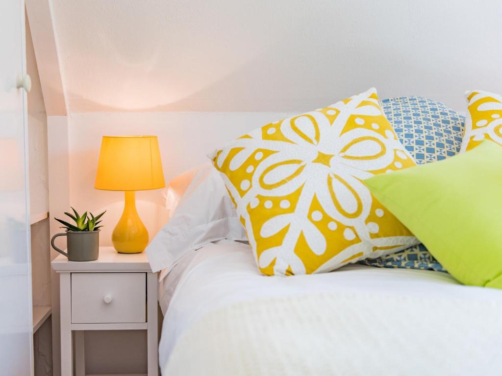 a bed with blue and white pillows and a lamp at Mitford Lodge in Wye