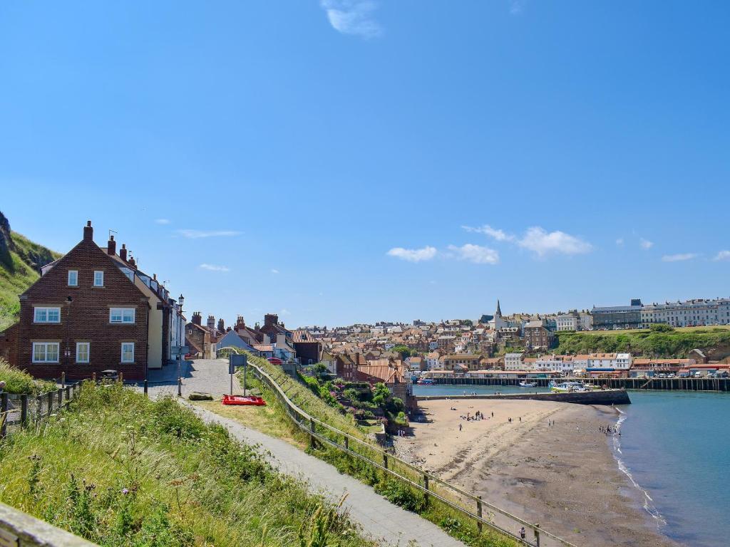 Blick auf einen Strand mit einem Haus neben dem Wasser in der Unterkunft Captains Cottage - E3643 in Whitby