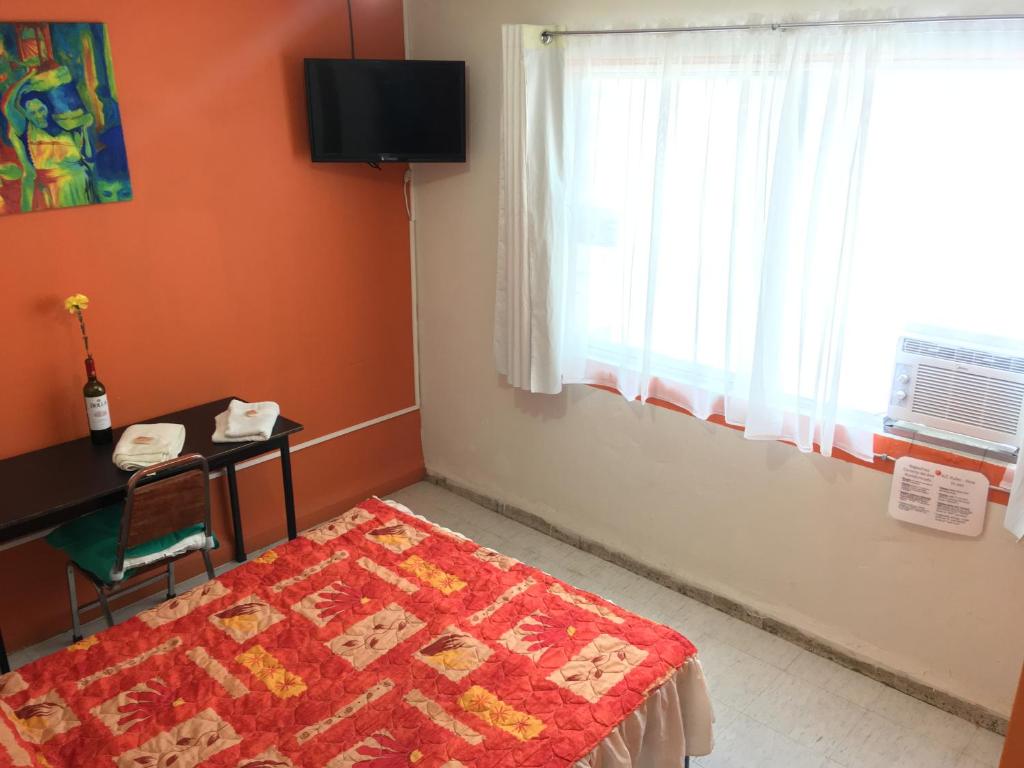 1 dormitorio con cama, escritorio y ventana en Habitacion privada en Centro Lopez Mateos con Aire Acondicionado Oficina Estacionamiento en León